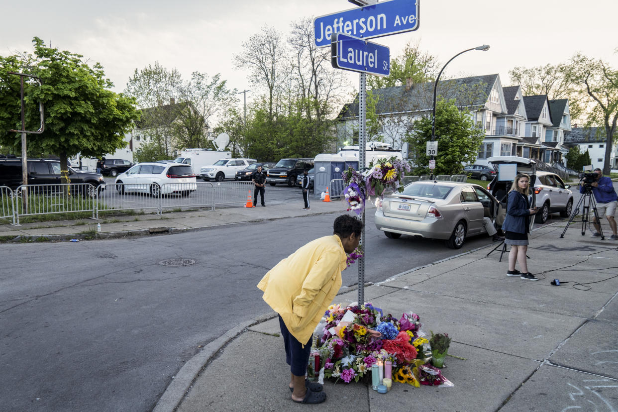 A woman contributes to a shrine situated on Jefferson Avenue in Buffalo, N.Y. on May 15, 2022. (Joshua Thermidor for NBC News)