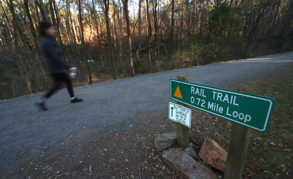 A woman walks along the Rail Trail Loop toward the Butterfly Garden Tuesday afternoon, Jan. 25, 2022, at the Gateway Trail in Kings Mountain.