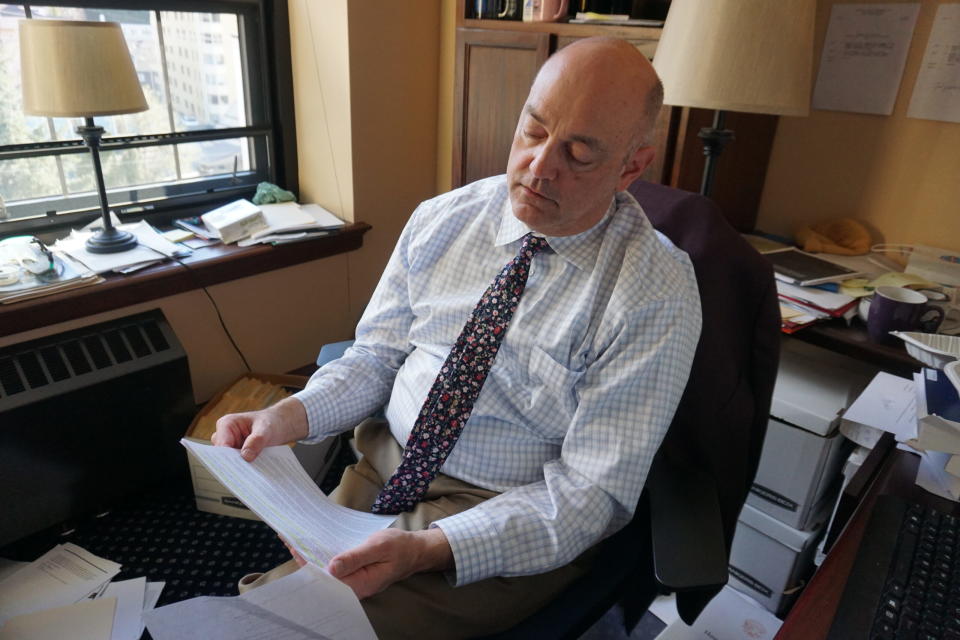 Rep. Andy Josephson, D-Anchorage, in his office on April 25, 2024, reviews a printout of a 1987 Alaska Supreme Court decision that found elimination of state mineral royalties to be a violation of the Alaska Statehood Act. (Photo by Yereth Rosen/Alaska Beacon)