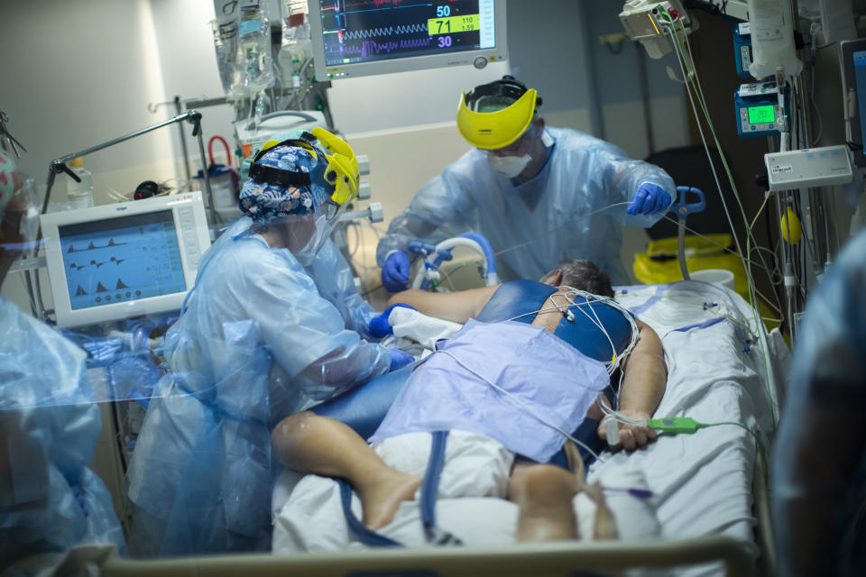 FILE - In this April 28, 2021, file photo, medical staff attend to a COVID-19 patient in the intensive care ward of the Erasme hospital in Brussels. In both the U.S. and the EU, officials are struggling with the same question: how to boost vaccination rates to the max and end a pandemic that has repeatedly thwarted efforts to control it. (AP Photo/Francisco Seco, File)