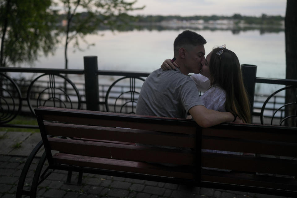 FILE - A couple kiss at Natalka Park in Kyiv, Ukraine, Tuesday, June 7, 2022. With war raging on fronts to the east and south, the summer of 2022 is proving bitter for the Ukrainian capital, Kyiv. The sun shines but sadness and grim determination reign.(AP Photo/Natacha Pisarenko, File)