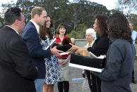 Britain's Prince William, second left, and his wife, Kate, the Duchess of Cambridge, third left, are given a gift by Aboriginal elders Chris Tobin, right, Aunty Sharon Brown, and Aunty Sharon Halls, third left, while on a tour of Echo Point with Randall Walker, left, CEO of Blue Mountains Lithgow and Oberon Tourism, and Anthea Hammon, center, Joint Managing Director of Scenic World in Katoomba, Australia Thursday, April 17, 2014. The royal couple, along with Prince George, are on the 10-day official visit. (AP Photo/Rick Rycroft, Pool)