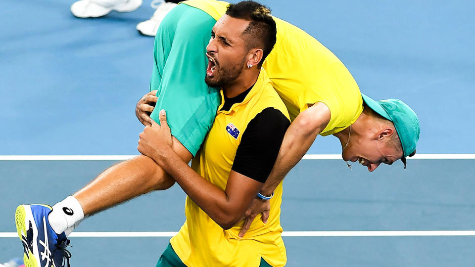 Nick Kyrgios is pictured carrying teammate Alex de Minaur after winning their men's doubles match against Jamie Murray and Joe Salisbury of Britain at the ATP Cup.