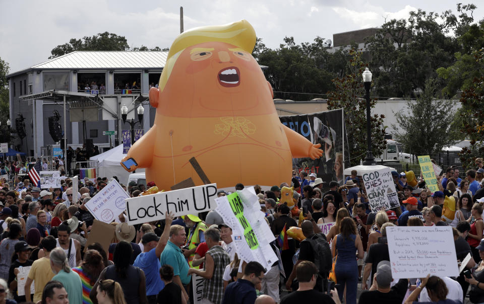 An inflatable Baby Trump balloon towers over protestors during a rally Tuesday, June 18, 2019, in Orlando, Fla. A large group was protesting against President Donald Trump was rallying near where Trump was announcing his re-election campaign. President Trump is being trolled by an angry diaper-clad caricature armed with a cell phone. It’s Baby Trump, the blimp that has become synonymous with resistance to the American president. The balloon has been cloned multiples times over and become something of a celebrity _ for at least one slice of the U.S. electorate. He’s also emerged as a rallying point for supporters of the president who see the blimp as evidence of just how over-the-top the opposition has become.(AP Photo/Chris O'Meara)