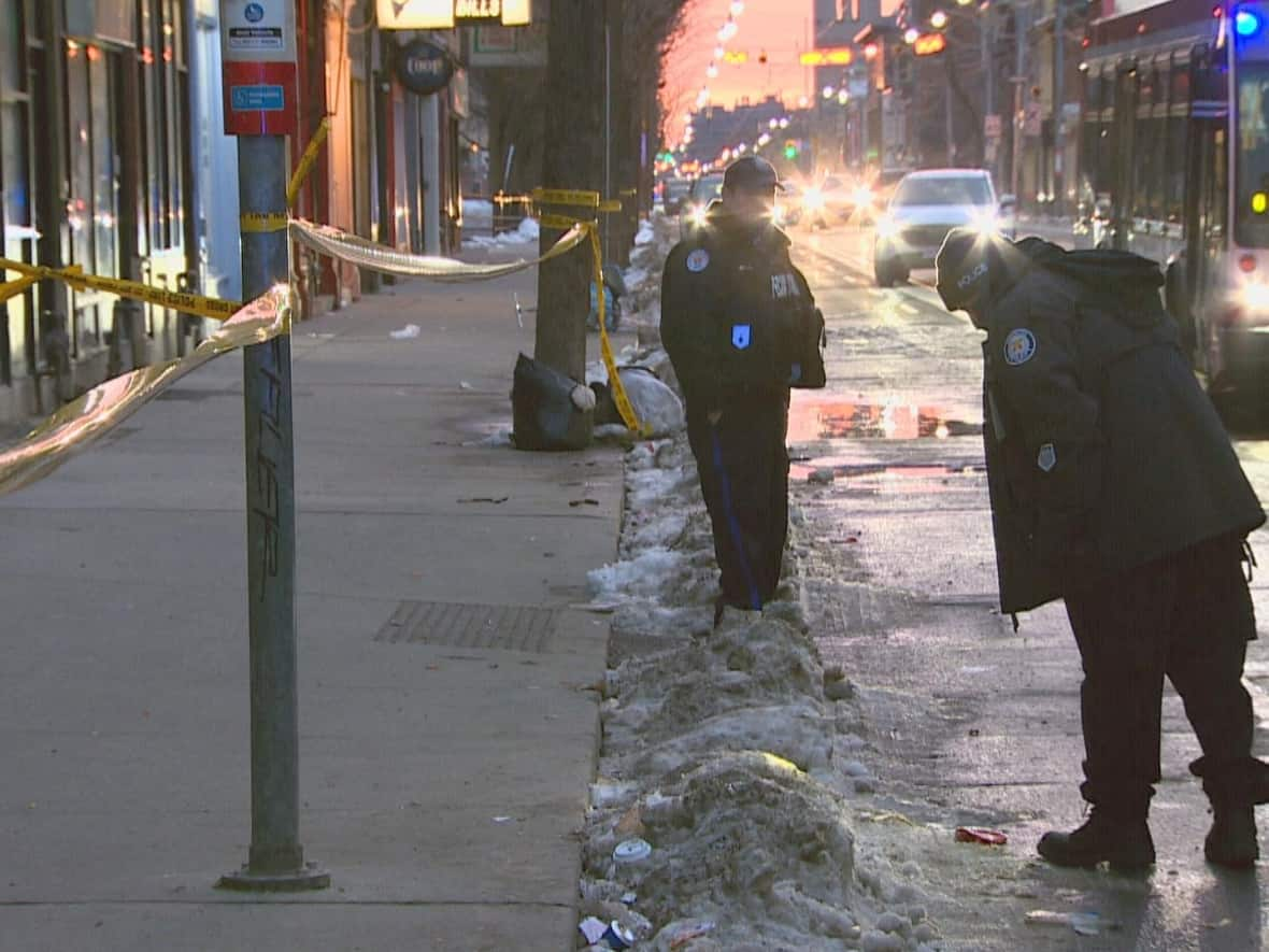 Toronto police officers are pictured at the scene of the fatal stabbing near Queen Street East and Sherbourne Street on March 6. One man was arrested Friday in connection with the stabbing, police say. (Christopher Mulligan/CBC - image credit)