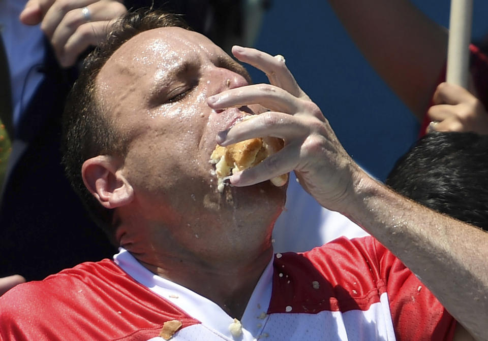 Joey Chestnut stuffs his mouth with hot dogs during the men's competition of Nathan's Famous July Fourth hot dog eating contest, July 4, 2019, in New York's Coney Island. (Photo: Sarah Stier/AP)