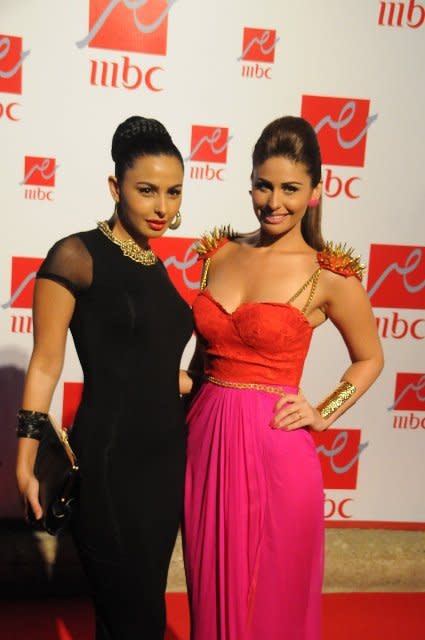 Sister artists Mai Selim and Mais Hamdan pose to photographers at the event.