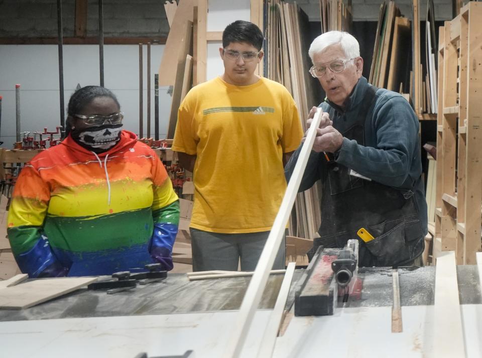 Eva Hubbart and Manrique Valladares watch Ed Koscik split wood during the hands-on educational experience of building a boat Monday, Feb. 5, 2024, at All Hands Boatworks in Milwaukee.