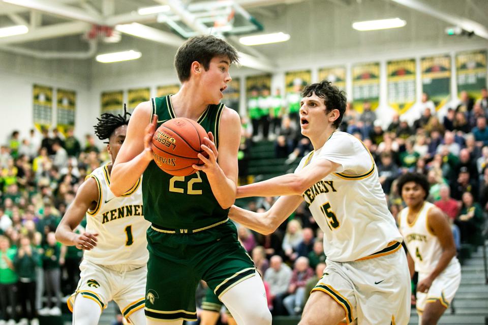 Iowa City West's Jack McCaffery, center, looks to pass as Cedar Rapids Kennedy's Kenzie Reed, left, and Micah Schlaak defend during a Class 4A high school boys basketball game on Tuesday.