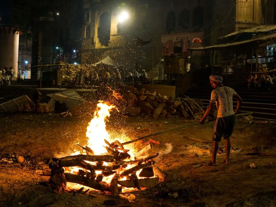 A member of the Dom community tends to a funeral pyre in 2018.