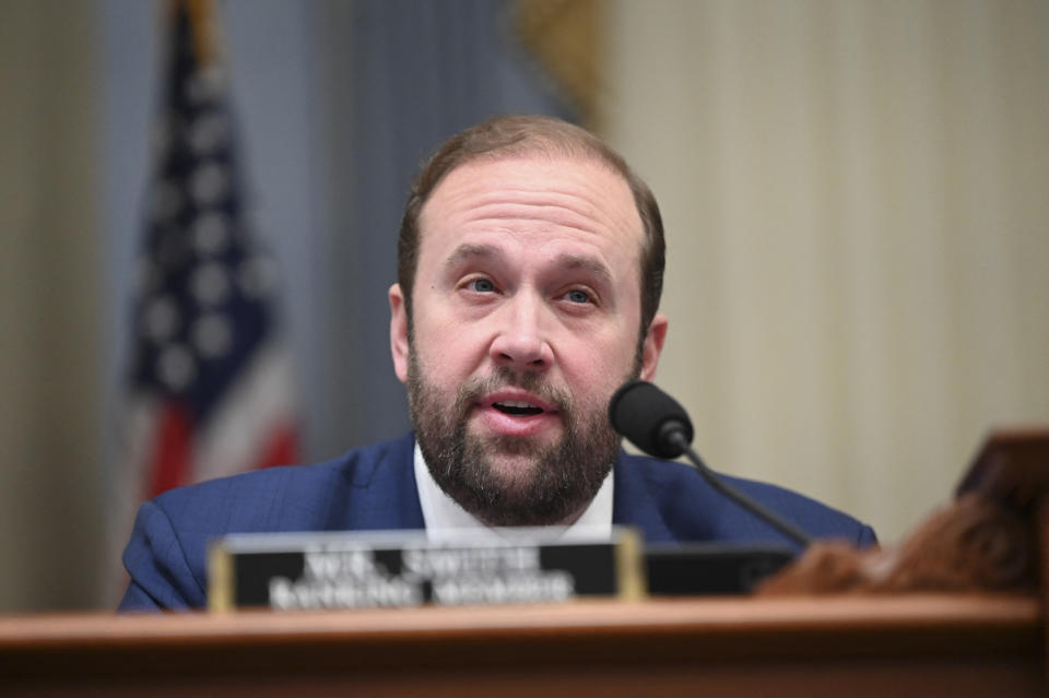 Representative Jason Smith speaks into a microphone at a meeting.