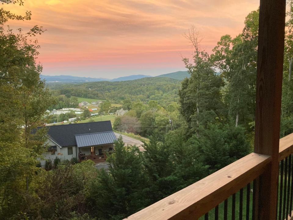 View of a sunset and treetops from a balcony