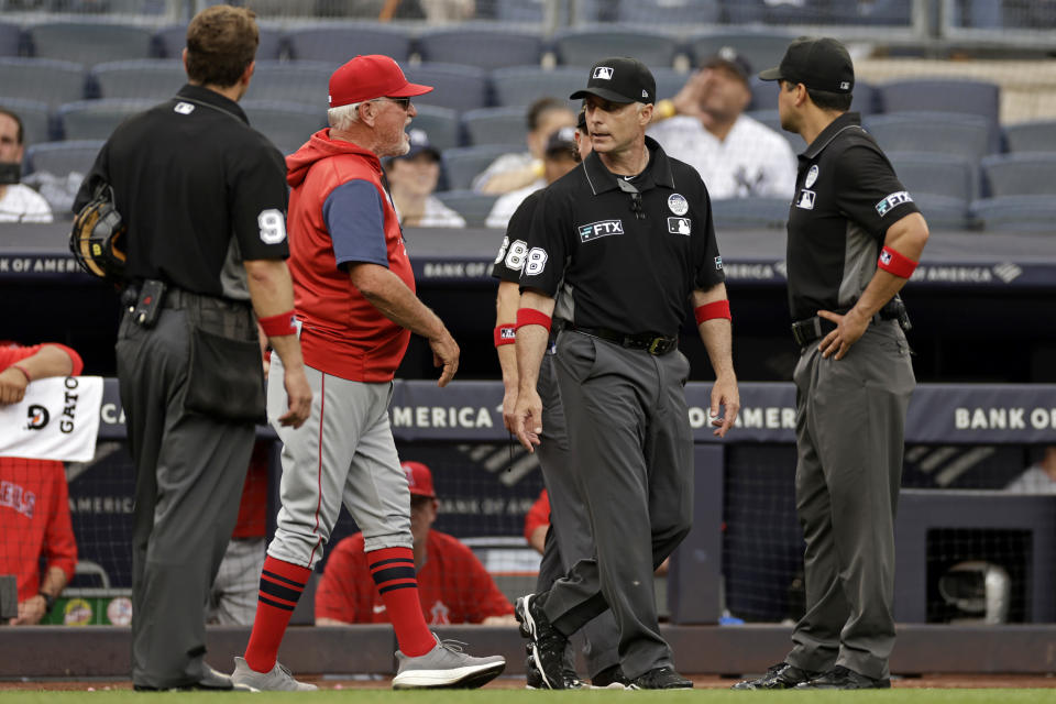 Los Angeles Angels manager Joe Maddon , second from left, argues with the umpire crew during the seventh inning of the first baseball game of a doubleheader against the New York Yankees on Thursday, June 2, 2022, in New York. (AP Photo/Adam Hunger)