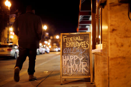 FILE PHOTO: A sign the reads "Federal employees all day happy hour" is displayed at a local bar as the partial U.S. government shutdown enters its third week in Washington, U.S., January 11, 2019. REUTERS/Carlos Barria/File Photo
