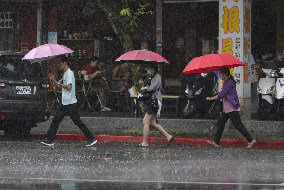 People walk in the rain as Typhoon Gaemi approaches in Taipei, Taiwan, Wednesday, July 24, 2024. (AP Photo/Chiang Ying-ying)