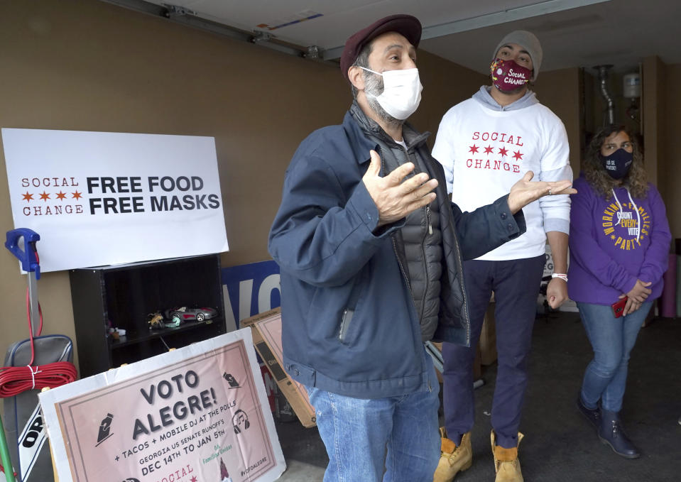 Ricardo Mireles, left, discusses the Working Families Party campaign as Todd Belcore and Stephanie Lopez-Burgus, right, listen Wednesday, Dec. 16, 2020, in Lawrenceville, Ga. (AP Photo/Tami Chappell)