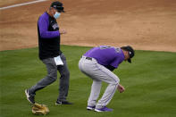 Colorado Rockies starting pitcher Kyle Freeland (21) kneels after sustaining a shoulder injury during the third inning of a spring training baseball game against the Oakland Athletics, Tuesday, March 23, 2021, in Mesa, Ariz. (AP Photo/Matt York)