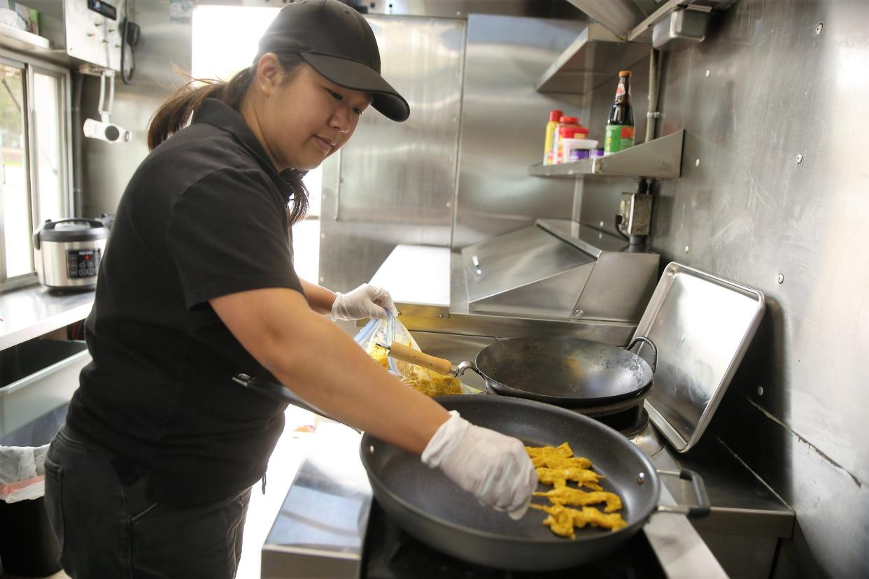 Maneegan "Meg" Brauer cooks chicken satay in the Thai Dakota food truck June 1, 2022.