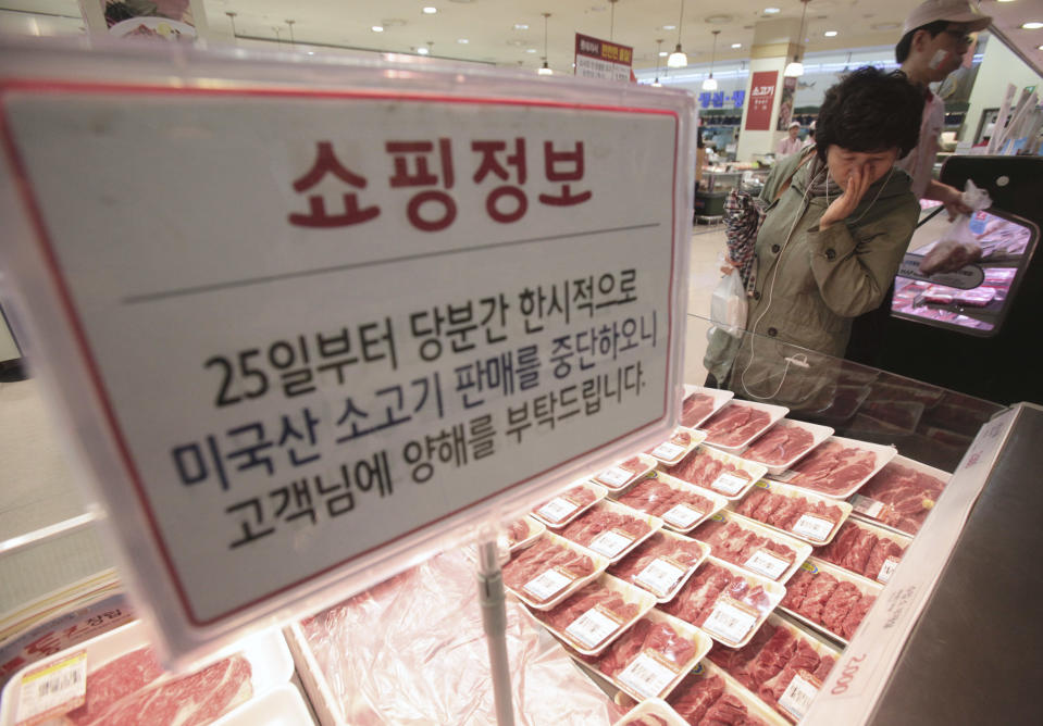 A South Korean woman watches Australian beef on the shelves at a Lotte Mart store in Seoul, South Korea, Wednesday, April 25, 2012. Two major South Korean retailers, including Lotte Mart, suspended sales of U.S. beef Wednesday following the discovery of mad cow disease in a U.S. dairy cow. Reaction elsewhere in Asia was muted with Japan saying there's no reason to restrict imports. The letters on a card read " Starting from the 25th, we will temporarily stop the sales of the US beef. Thank you for your understanding". (AP Photo/Ahn Young-joon)