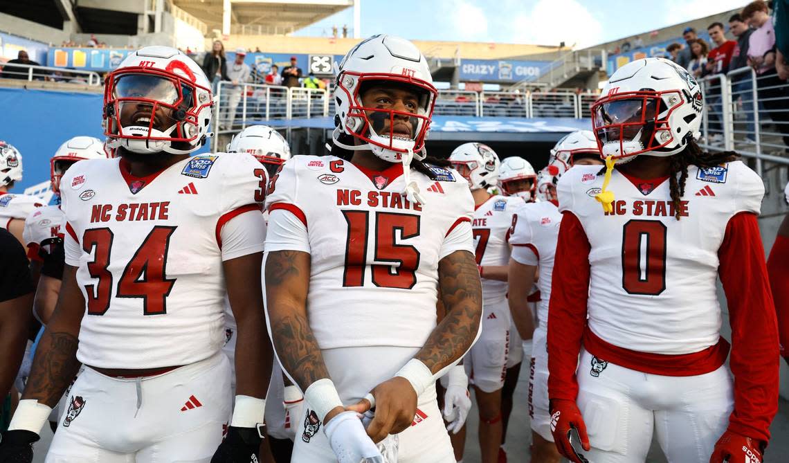 From left, N.C. State’s Delbert Mimms III (34), Keyon Lesane (15) and Sean Brown (0) get ready to run out onto the field to warm up before N.C. State’s game against Kansas State in the Pop-Tarts Bowl at Camping World Stadium in Orlando, Fla., Thursday, Dec. 28, 2023. Ethan Hyman/ehyman@newsobserver.com