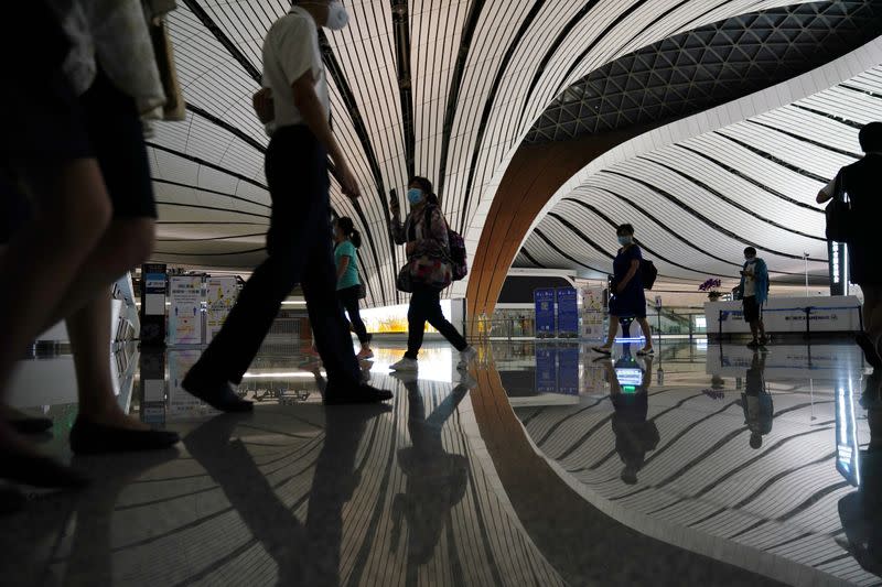 People wearing face masks following the coronavirus disease (COVID-19) outbreak are seen at Beijing Daxing International Airport in Beijing