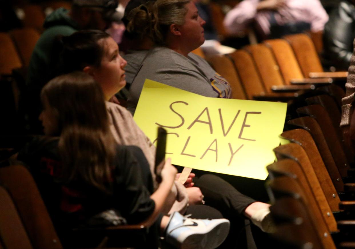 A person holding a sign sits Monday, April 17, 2023, at the South Bend School Board meeting at LaSalle Academy in South Bend.