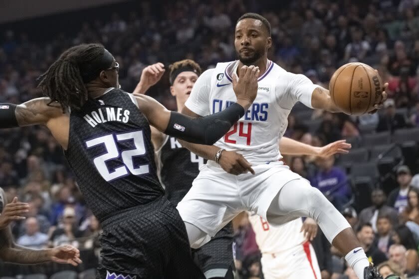 Los Angeles Clippers forward Norman Powell passes the ball around Sacramento Kings center Richaun Holmes