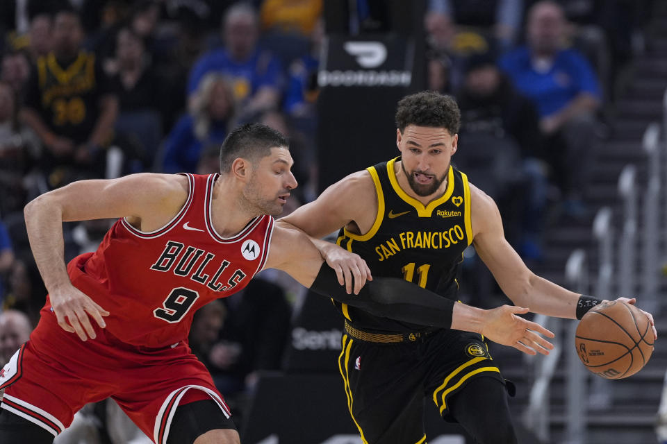 Chicago Bulls center Nikola Vucevic, left, tries to poke the ball away from Golden State Warriors guard Klay Thompson during the first half of an NBA basketball game Thursday, March 7, 2024, in San Francisco. (AP Photo/Godofredo A. Vásquez)