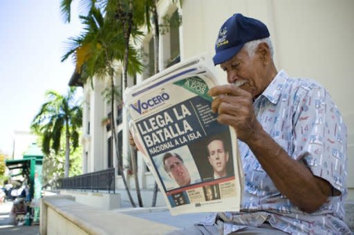 A man reads the newspaper "El Vocero" with a front page depicting both Mitt Romney and Rick Santorum March 14, 2012 in Old San Juan, Puerto Rico