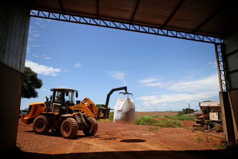 FILE PHOTO: A tractor is seen loading fertilizer before spreading it in a soybean field