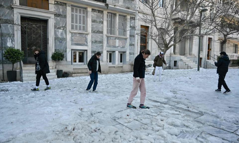 People try to walk on ice in central Athens.