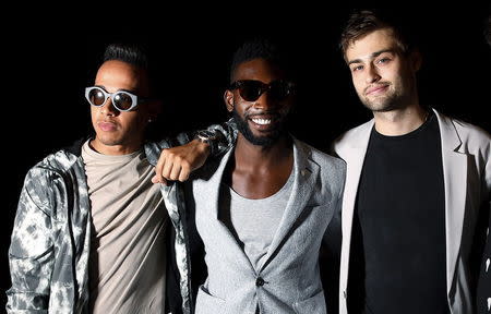 Formula One racing driver Lewis Hamilton (L), musician Tinie Tempah (C) and actor Douglas Booth pose for photographers following the presentation of the Topman Design Spring/Summer 2015 collection during "London Collections: Men" in London, Britain June 12, 2015. REUTERS/Suzanne Plunkett