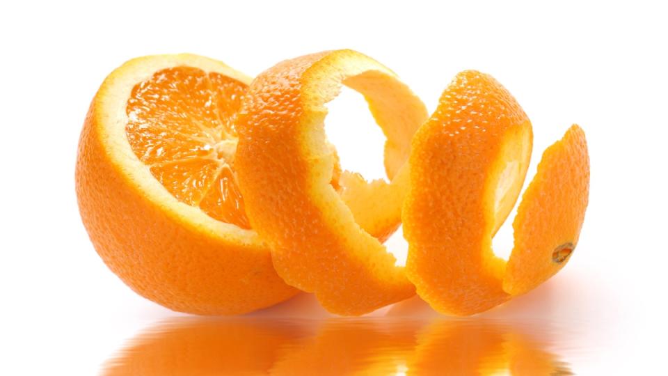 An orange partially peeled, which is one of the best fast-acting heartburn remedies