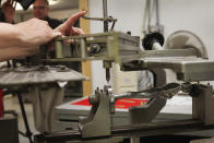 CHICAGO, IL - FEBRUARY 09: A worker demonstrates the process of engraving a serial number on an Oscar statuette at R.S. Owens & Company February 9, 2012 in Chicago, Illinois. R.S. Owens manufactures the Oscar statuettes which are presented at the annual Academy Awards by the Academy of Motion Picture Arts and Sciences. After the theft of the statuettes prior to the 2000 Academy Awards the company began casting the statuettes one year in advance of the show. (Photo by Scott Olson/Getty Images)