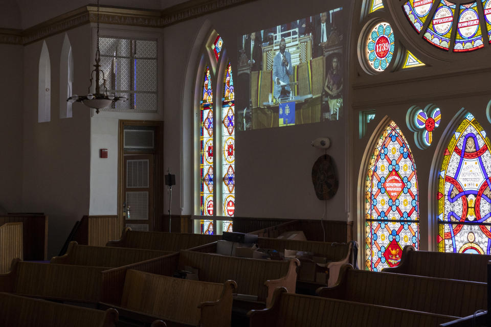 A projection of a sermon is displayed on a wall during Palm Sunday services at the Metropolitan AME Church in Washington, Sunday, March 24, 2024. Rev. William Lamar IV at Washington, D.C.’s historic Metropolitan AME has adjusted to offering both virtual and in-person services since the COVID-19 pandemic. After a noticeable attendance drop, more Metropolitan congregants are choosing in-person worship over virtual, even as they mourn members who died from COVID-19. (AP Photo/Amanda Andrade-Rhoades)
