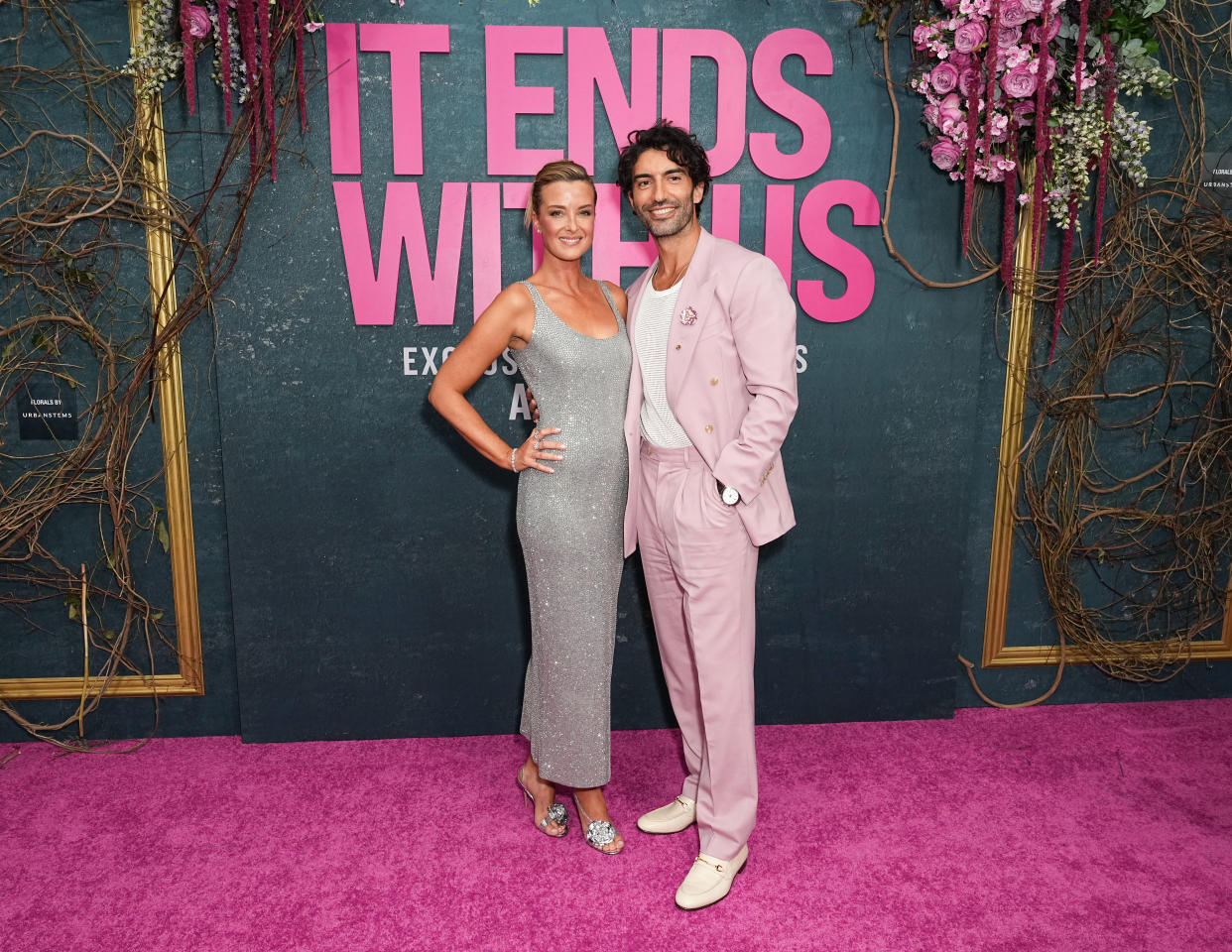 Emily Baldoni and Justin Baldoni pose on the red carpet.