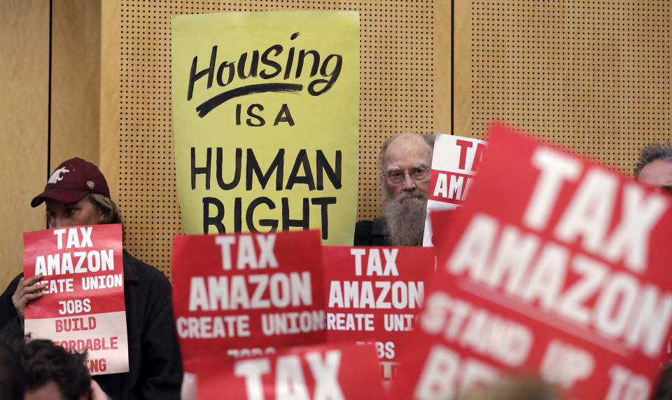 Protesters at a Seattle City Council meeting. Earlier this year, the city passed a law that would have taxed large corporations, including Amazon, to fund homelessness services. The law was repealed after Amazon funded a campaign against it. (Photo: Elaine Thompson/ASSOCIATED PRESS)