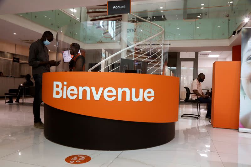 People are pictured at a bank of the French mobile operator Orange in Abidjan, Ivory Coast