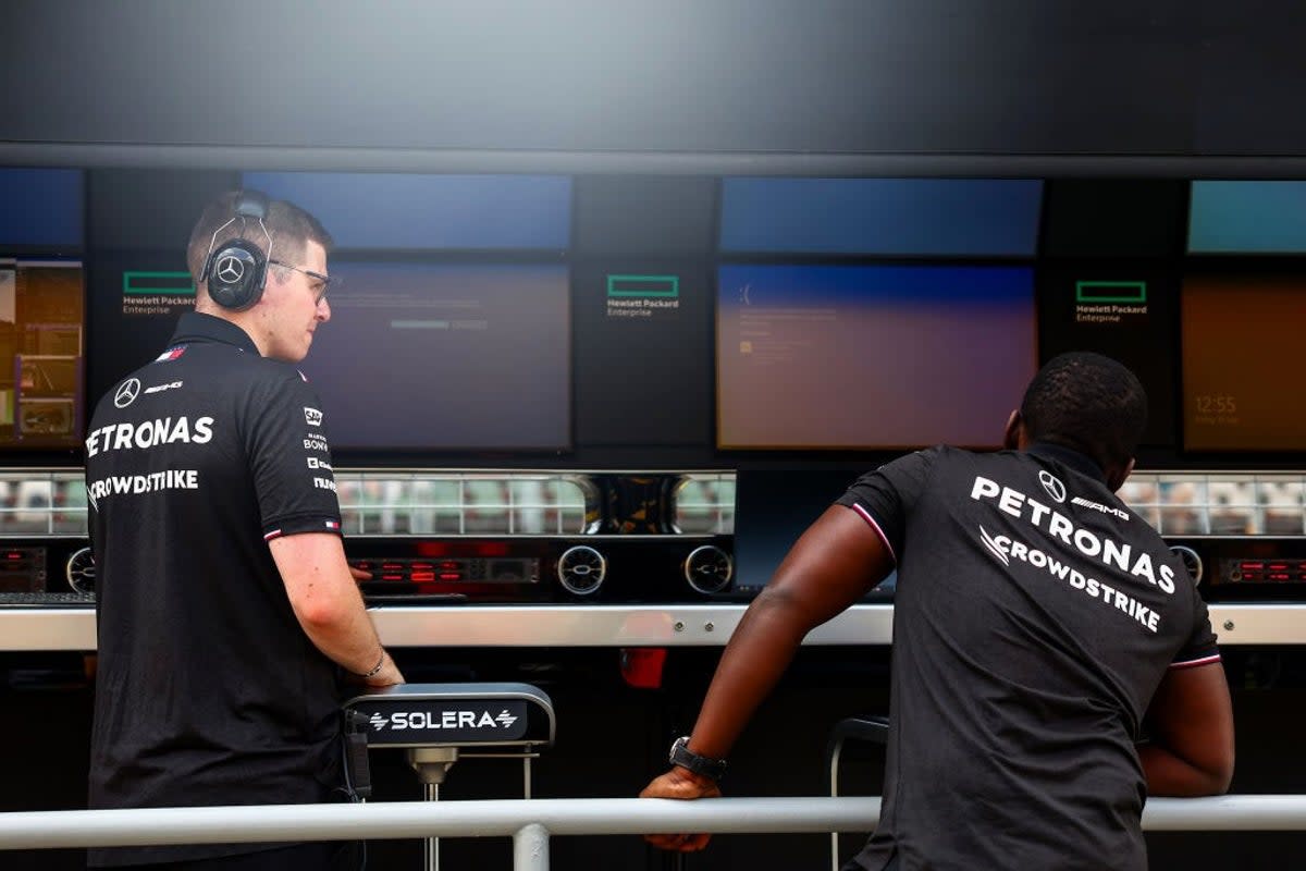 A Mercedes team member, whose shirt bears the logo of team sponsor Crowdstrike, looks on as Windows error screens are seen on their pitwall at the F1 Grand Prix of Hungary on 19 July, 2024 in Budapest, Hungary (Getty Images)