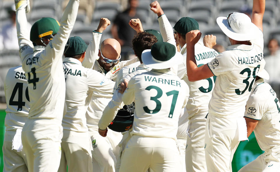 Nathan Lyon celebrates with teammates after finding out he'd taken his 500th Test wicket.