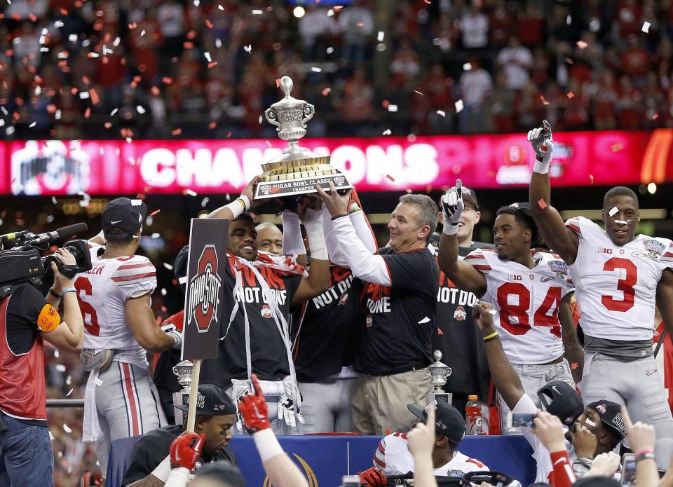 Coach Urban Meyer and running back Ezekiel Elliott hold up the trophy following a College Football Playoff semifinal win over Alabama in the Sugar Bowl in New Orleans on Jan. 1, 2015. Not every Ohio State season ends in a title, but they rarely end with losing records. Not since 1922-24 have the Buckeyes had consecutive losing seasons.