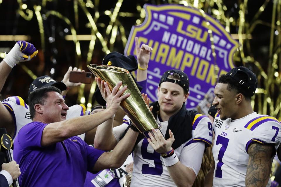 LSU coach Ed Orgeron and quarterback Joe Burrow hold the national championship trophy