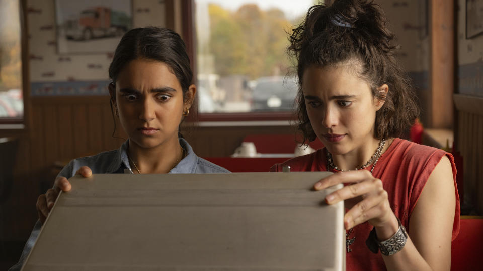 This image released by Focus Features shows Geraldine Viswanathan, left, and Margaret Qualley in a scene from "Drive-Away Girls." (Wilson Webb/Focus Features via AP)