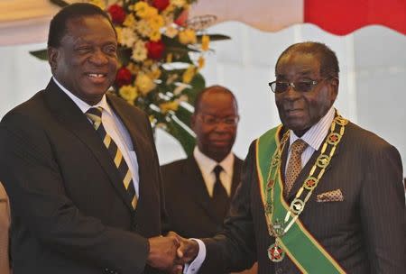 FILE PHOTO: President Robert Mugabe (R) greets Vice President Emmerson Mnangagwa as he arrives for Zimbabwe's Heroes Day commemorations in Harare, August 10, 2015. REUTERS/Philimon Bulawayo