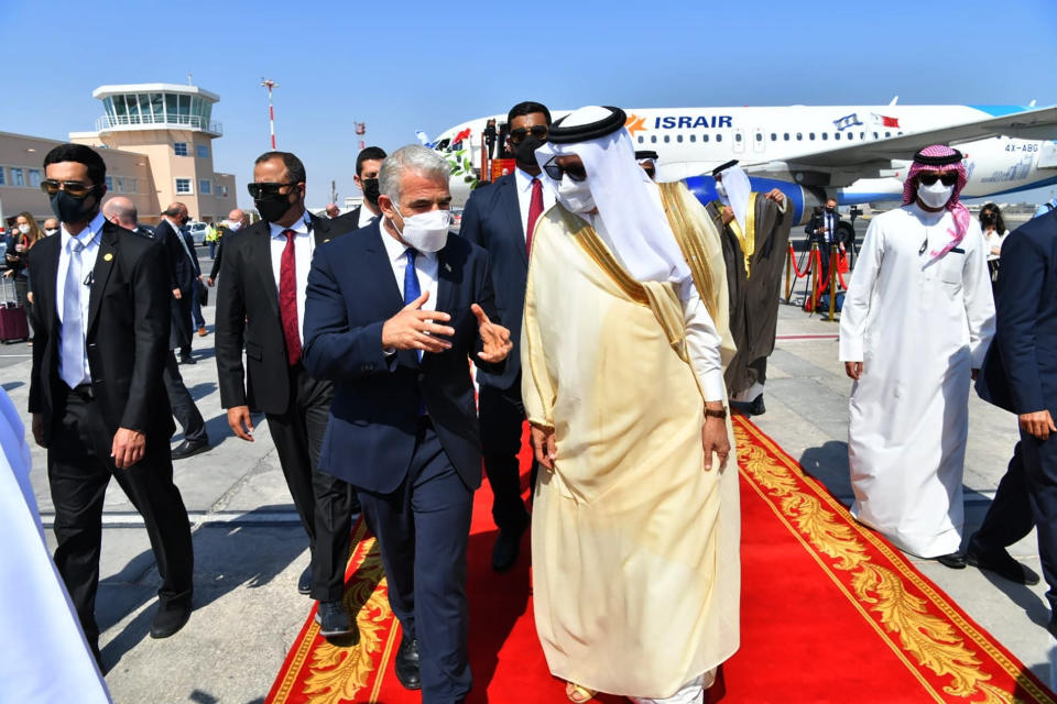 Israel's Foreign Minister Yair Lapid, center left, walks with his Bahraini counterpart, Abdullatif bin Rashid Alzayani, for the first high-level visit to the small Gulf state by a senior Israeli official since the signing of a landmark agreement to establish diplomatic ties between the two countries last year, in Manama, Bahrain, Thursday, Sept. 30, 2021. Lapid will inaugurate Israel’s embassy. (Shlomi Amshalem/GPO via AP)