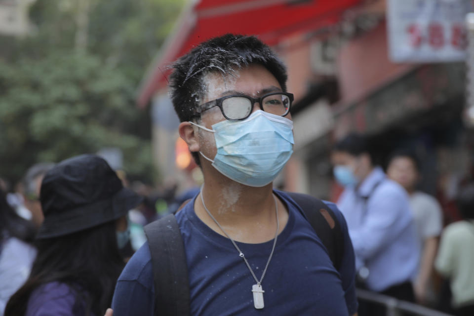 A man with his face covered in pepper spray walks down a street of Hong Kong Monday, Nov. 11, 2019. Hong Kong is in the sixth month of protests that began in June over a proposed extradition law and have expanded to include demands for greater democracy and other grievances. (AP Photo/Kin Cheung)