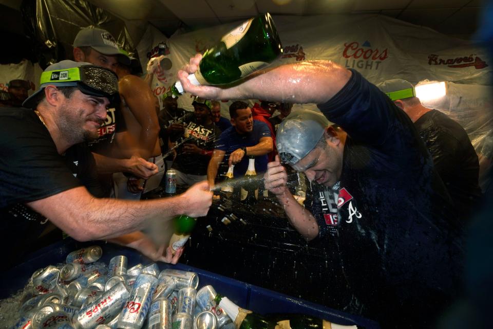 Atlanta Braves players celebrate in the club house after they clinched their fifth consecutive NL East title by defeating the Miami Marlins 2-1, in a baseball game, Tuesday, Oct. 4, 2022, in Miami. (AP Photo/Wilfredo Lee)