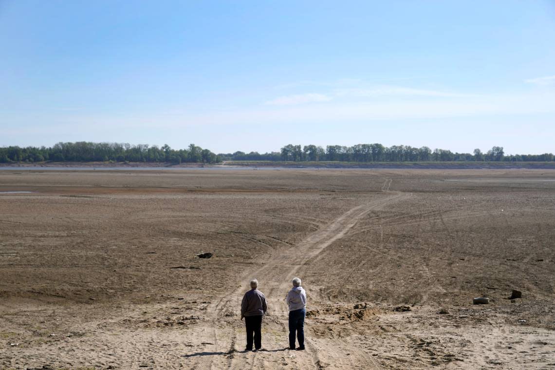 Linda Rawlings, left, and Carolyn Mungle stop to see were the normally wide Mississippi River has been reduced to a narrow trickle off in the distance, making barge and other travel along the river more difficult, Thursday, Oct. 20, 2022, near Portageville, Mo. Mungle, who has lived in the area for over 60 year says she has never seen the river so low.