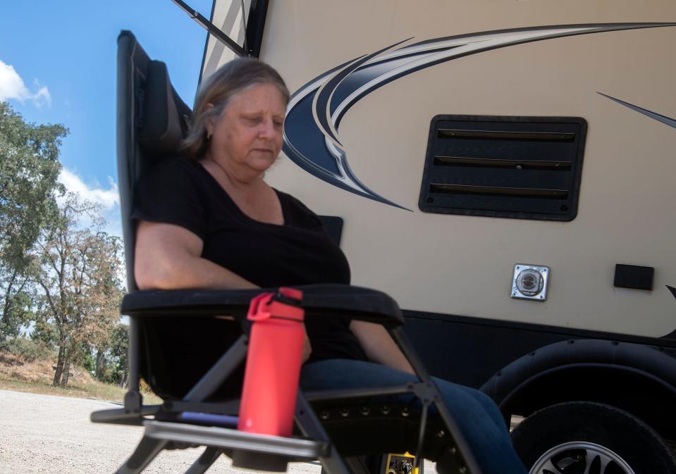 Kathy Beeston rests outside her trailer at the evacuation center at the Italian Picnic Grounds in Sutter Creek after fleeing the Electra Fire burning southeast of Jackson.