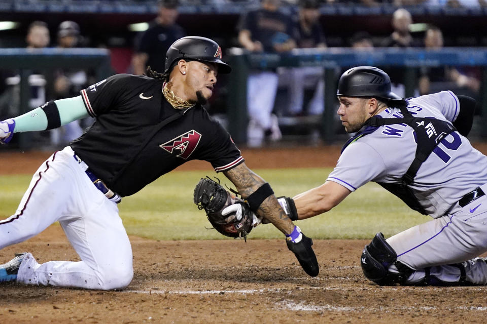 Colorado Rockies catcher Austin Wynns, right, tags out Arizona Diamondbacks' Ketel Marte at home plate during the sixth inning of a baseball game Wednesday, Sept. 6, 2023, in Phoenix. (AP Photo/Ross D. Franklin)